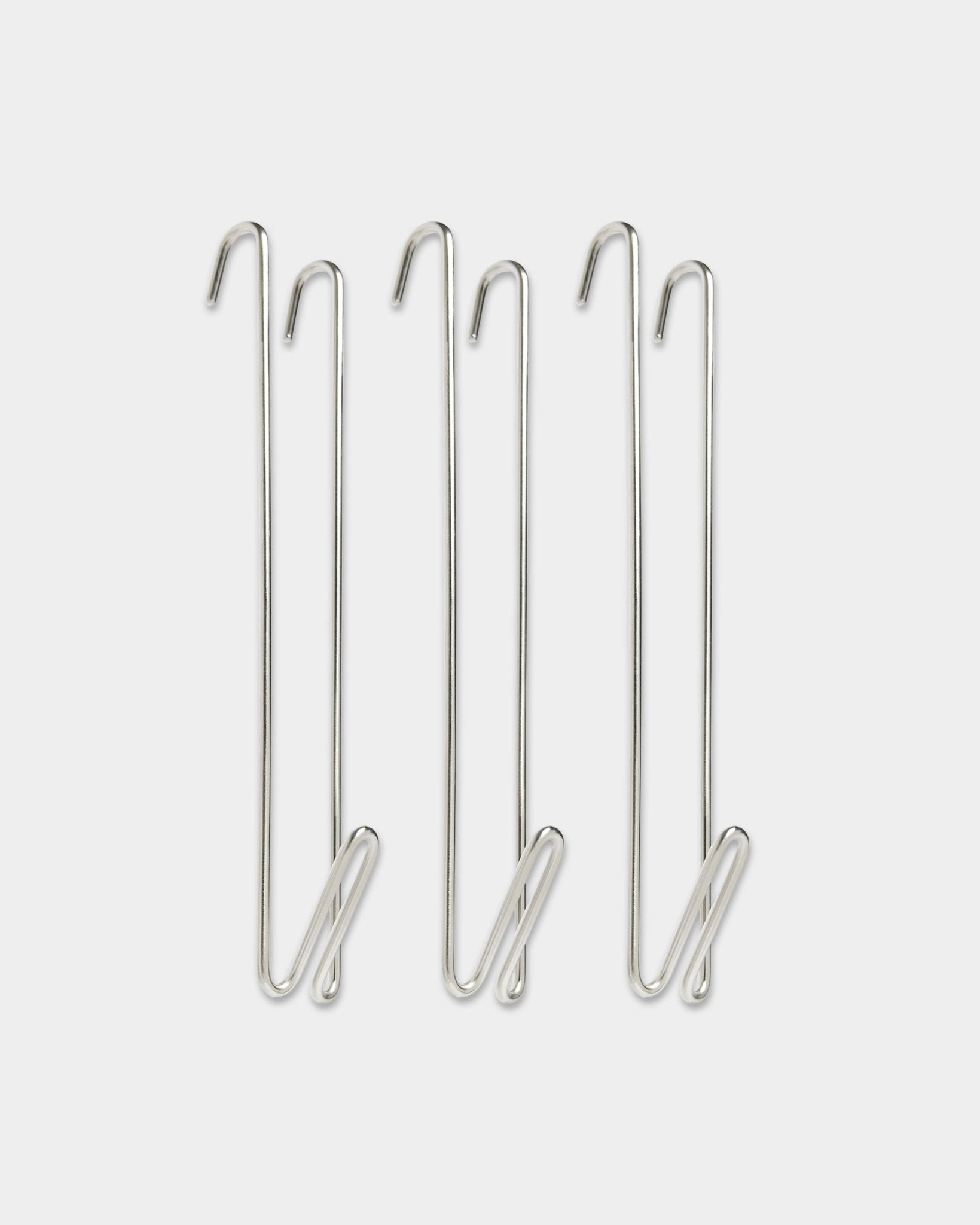 Tre prolunghe per barra appendiabiti Alva in acciaio inox di WoodUpp, con ganci in filo metallico steel BM1, progettate per aggiungere ulteriore spazio per appendere accanto ai pannelli acustici in legno.