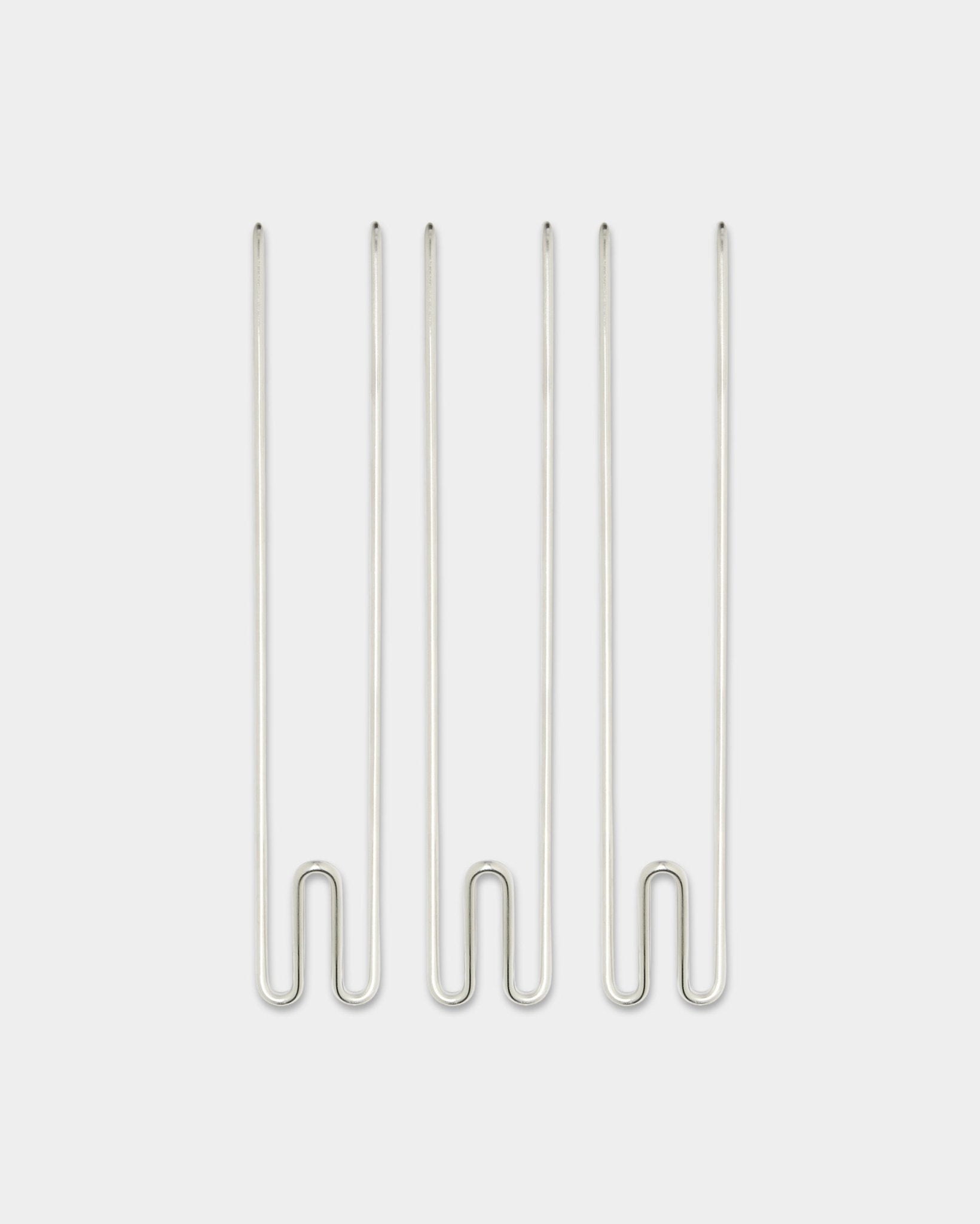 Tre accessori Alva Wire Hook / BM1 di WoodUpp, lunghi ganci in acciaio inox steel disposti in verticale su uno sfondo bianco semplice.