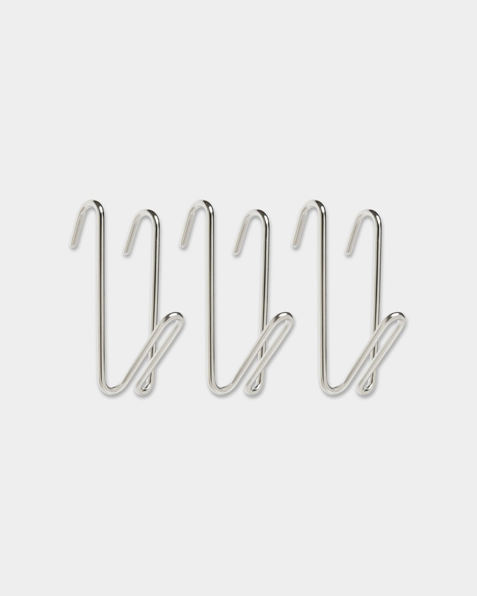 Tre Alva Wire Hook / BM1, in acciaio inox steel, short Misura della collezione CREATE di WoodUpp, con design ad anello, allineati in una fila su uno sfondo bianco semplice.