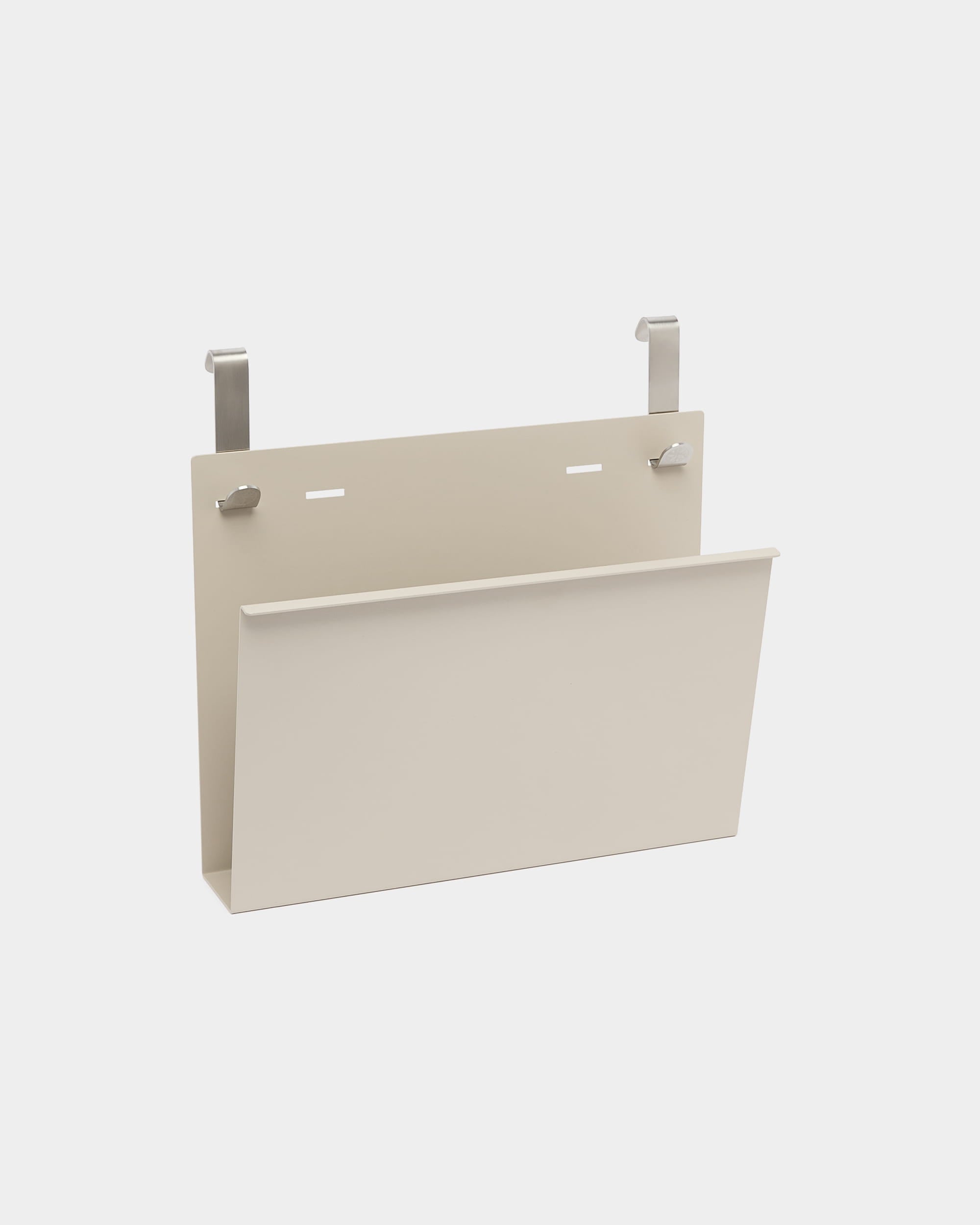 Il portariviste Nell di WoodUpp è un supporto in beige con verniciatura a polvere steel, dotato di due ganci argentati per essere appeso a divisori acustici nordici o pareti divisorie.