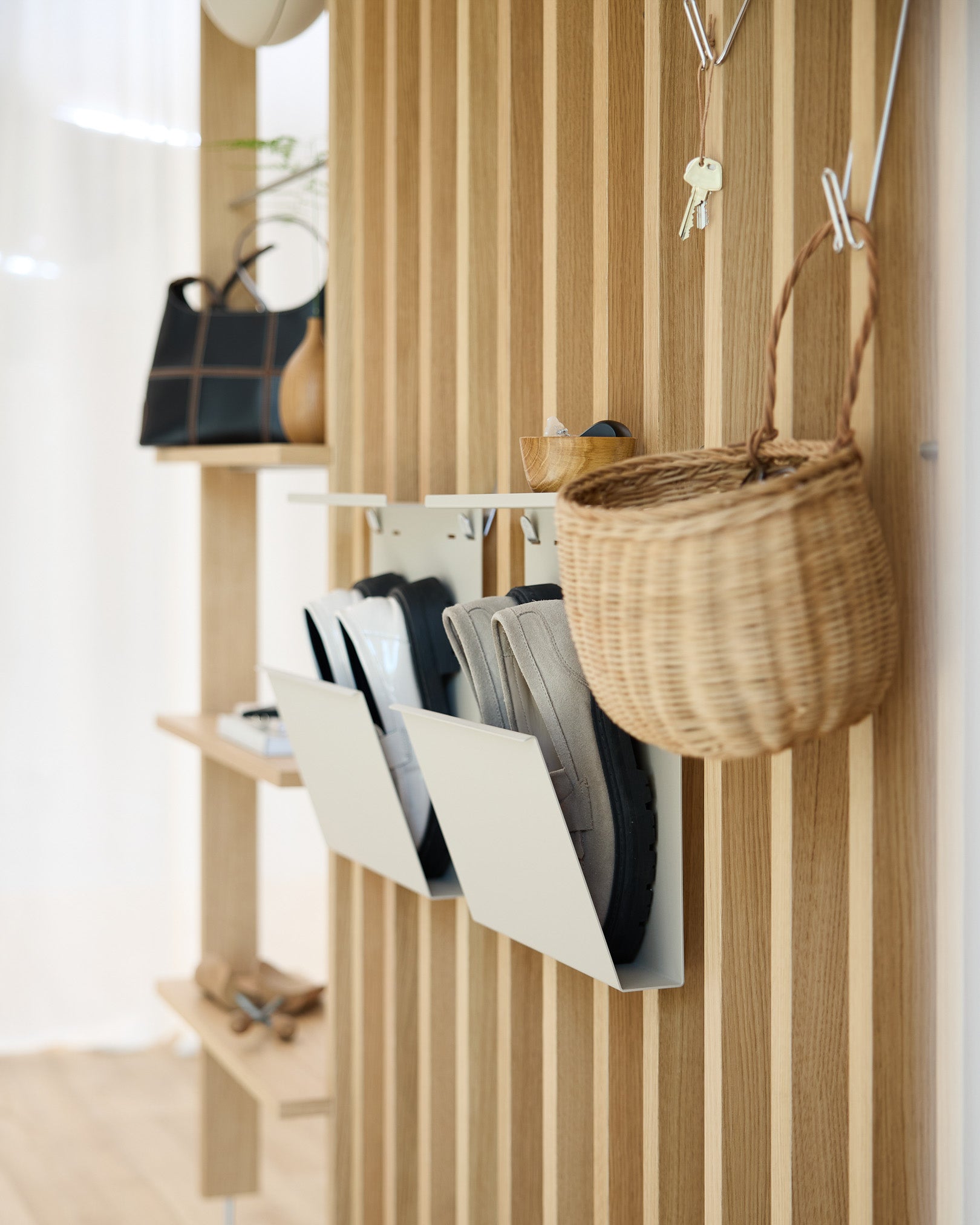 Ingresso moderno con beige Nell Shoe Storage di WoodUpp, pareti con pannelli acustici in legno Akupanel, ganci da parete, un cesto sospeso e una mensola con oggetti decorativi.