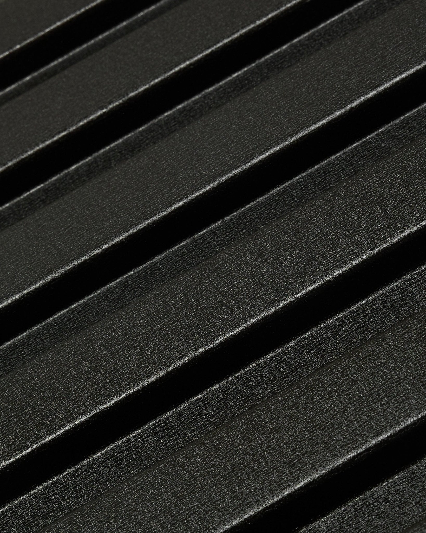 Primo piano del pannello per facciata esterna Aluwood di WoodUpp: superficie scura in alluminio riciclato testurizzato con scanalature diagonali in rilievo, dimensioni 240 x 45,1 cm.