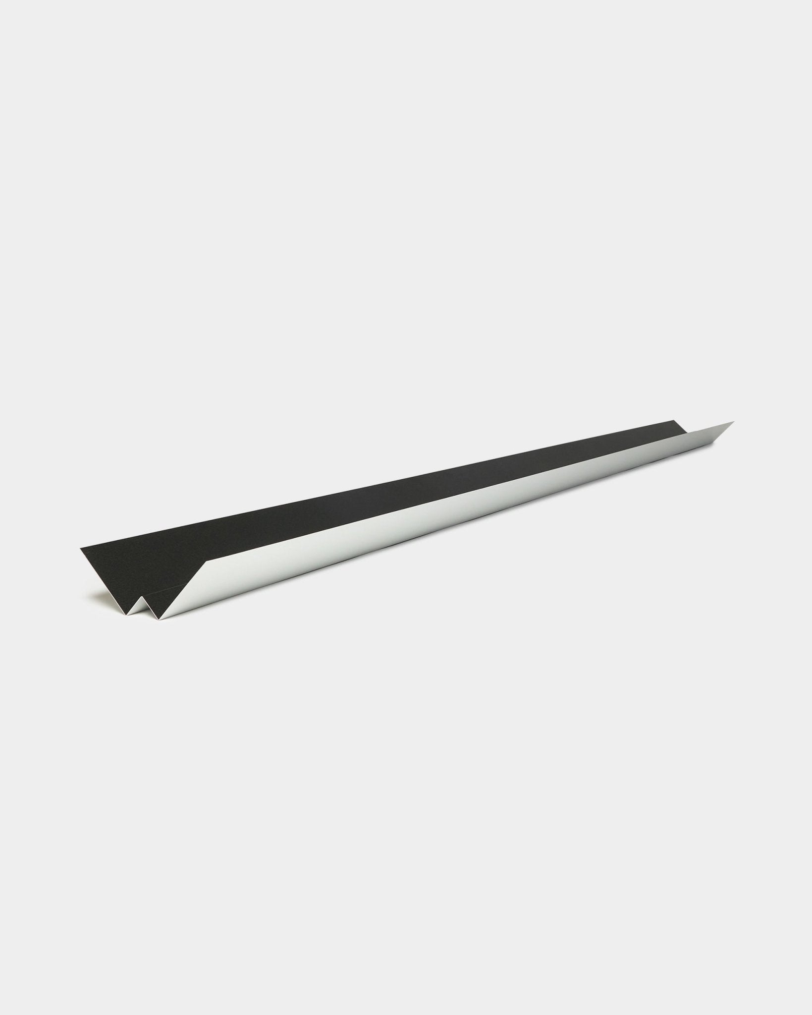 Design minimalista black e aeroplanino di carta bianco che richiama le linee essenziali e il profilo geometrico del pannello per facciata Aluwood Inside Corner di WoodUpp, 240 cm.