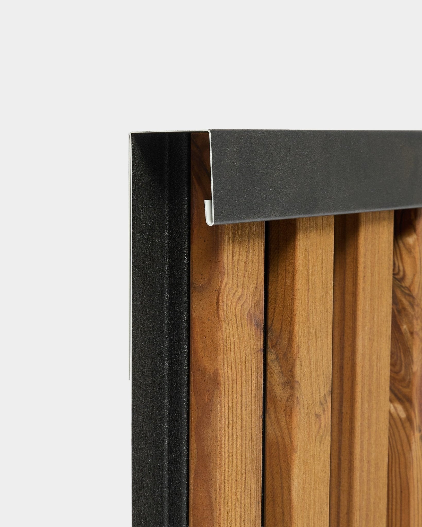 Primo piano del profilo di finitura WoodUpp Aluwood da 240 cm con bordo in alluminio black per pannelli per facciate esterne, mostrato su sfondo bianco.