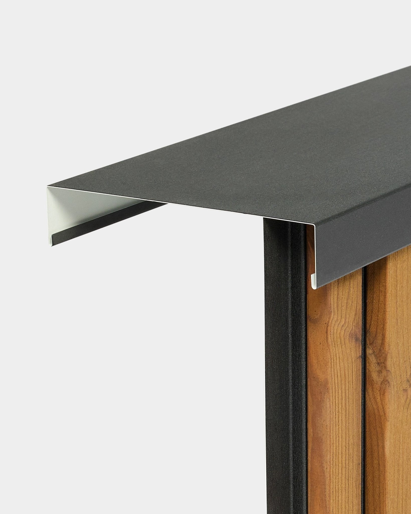 Primo piano della cimasa da parete Aluwood Level di WoodUpp (240 cm x 25 cm) installata sui pannelli di facciata vertical, con dettaglio del bordo in evidenza su sfondo neutro.