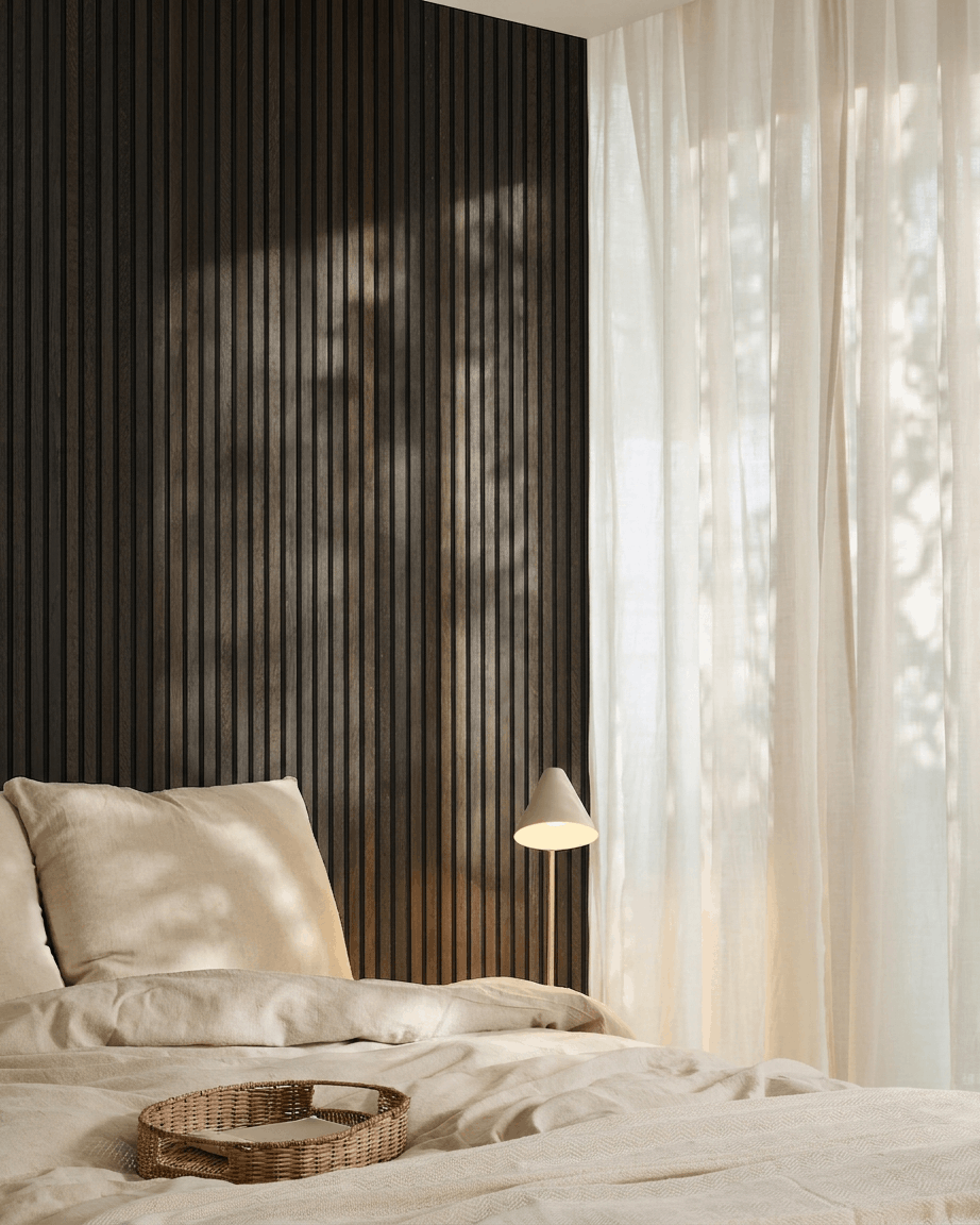 Camera da letto minimalista con letto beige, vassoio in vimini, dettagli Scandi e pannello acustico in legno Akupanel di WoodUpp in Rustic Smoked Oak, montato su una parete scura.