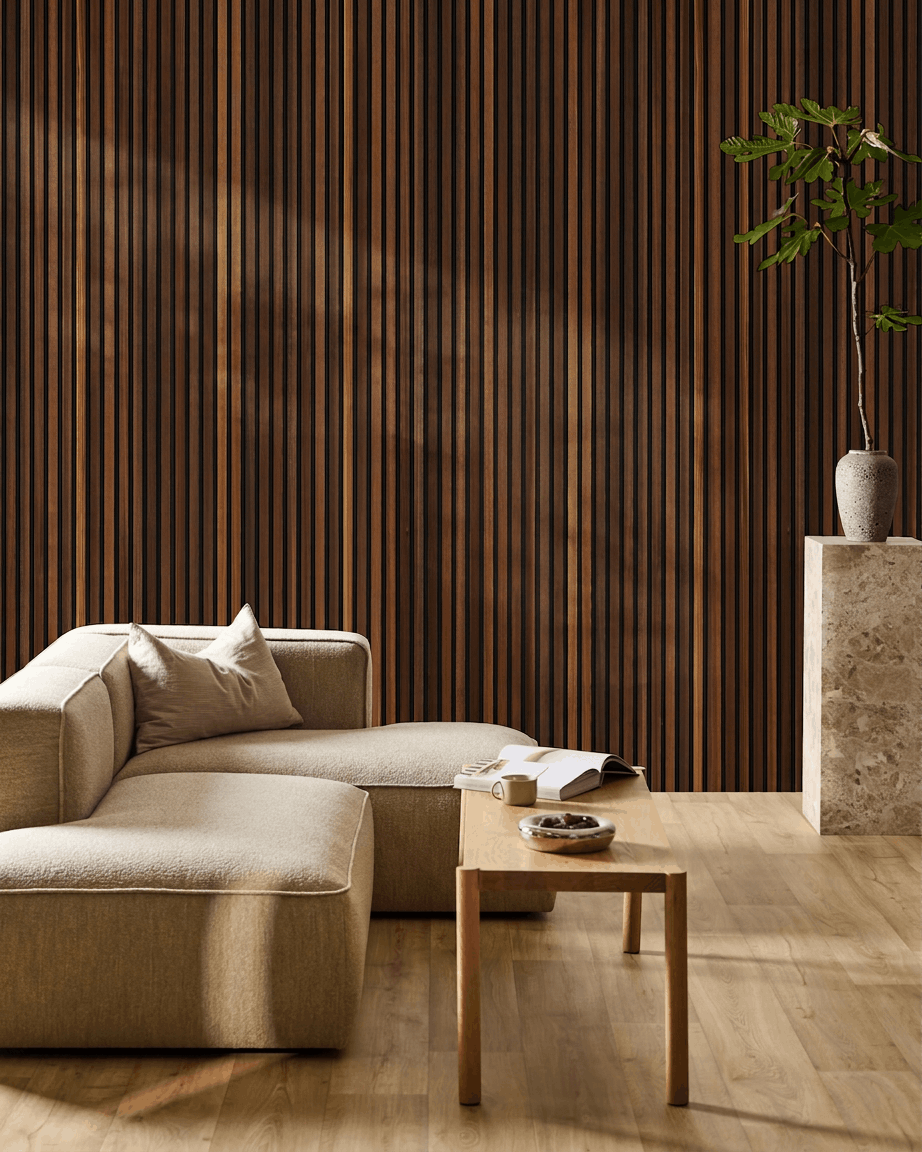 Soggiorno minimalista ambiente con un beige divano, tavolino da caffè con un libro aperto, pianta alta e pannello acustico in legno WoodUpp Akupanel in larice termotrattato sulla parete.