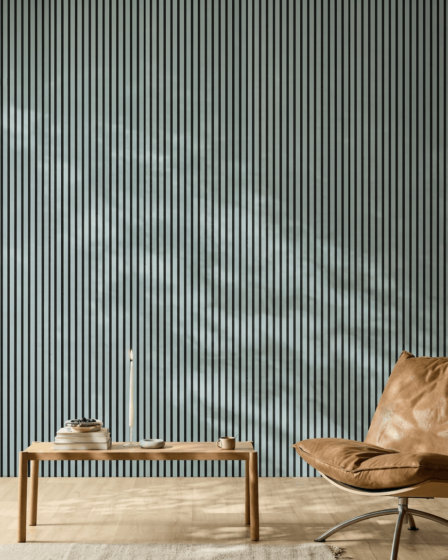 Spazio minimalista ambiente con una panca in legno, libri e una sedia in pelle brown davanti a WoodUpp Akupanel Pannello acustico nel colore Cloud con feltro black.