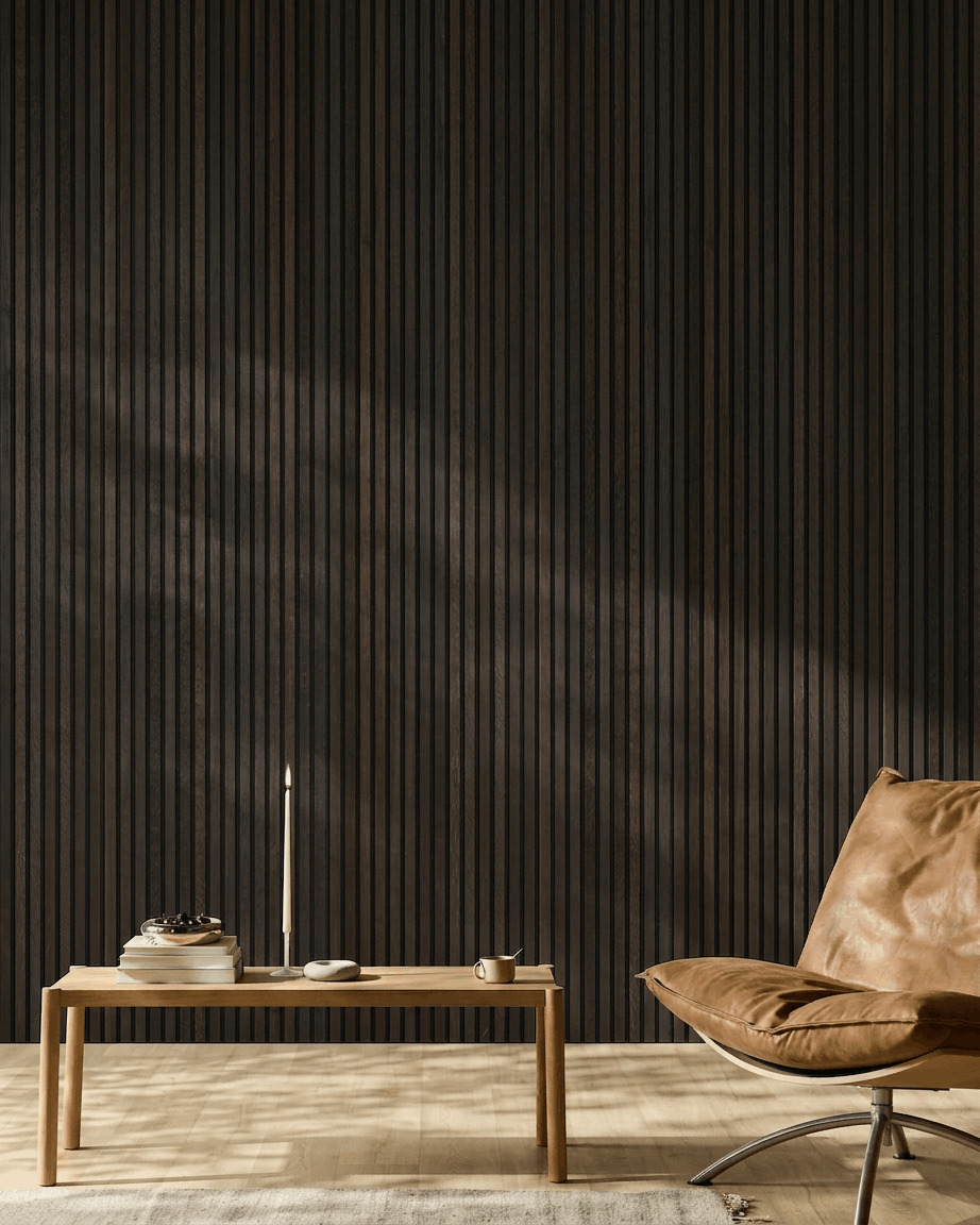 Interno ambiente minimalista con una poltrona in pelle brown, un tavolino da caffè e oggetti decorativi davanti a una parete di pannelli acustici in legno WoodUpp Akupanel Rustic Smoked Oak.