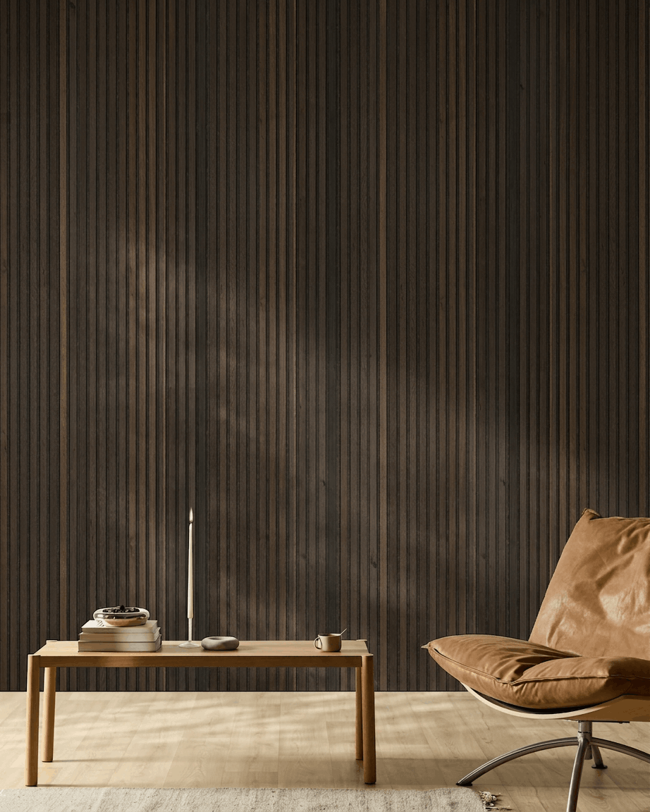 Interno nordico minimalista con sedia in pelle color cuoio, tavolo in legno, candela e tazza, su una parete WoodUpp <span data-glossary-id="">Akupanel Natural Wood Rustic Smoked Oak Pannello acustico</span>.