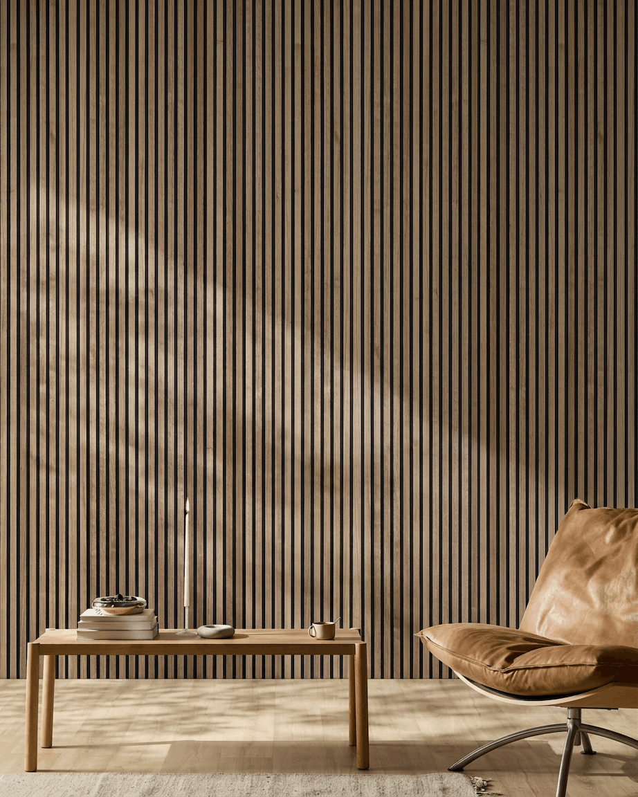 Interno nordico minimalista ambiente con pannello acustico in legno WoodUpp Akupanel in noce, sedia in pelle color cuoio e tavolino in legno con libri e una candela.