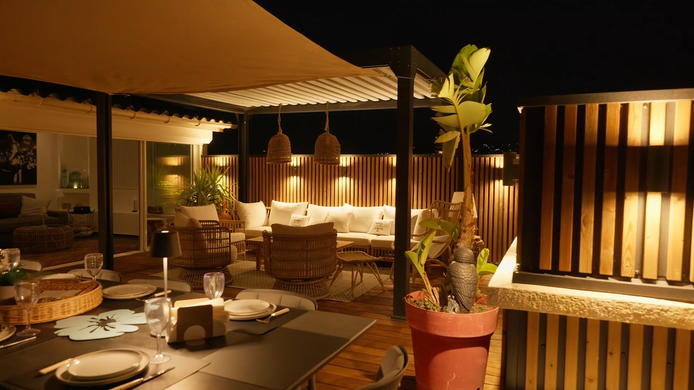 Aluwood aluminium slat cladding with warm wall lights on a rooftop terrace at night.