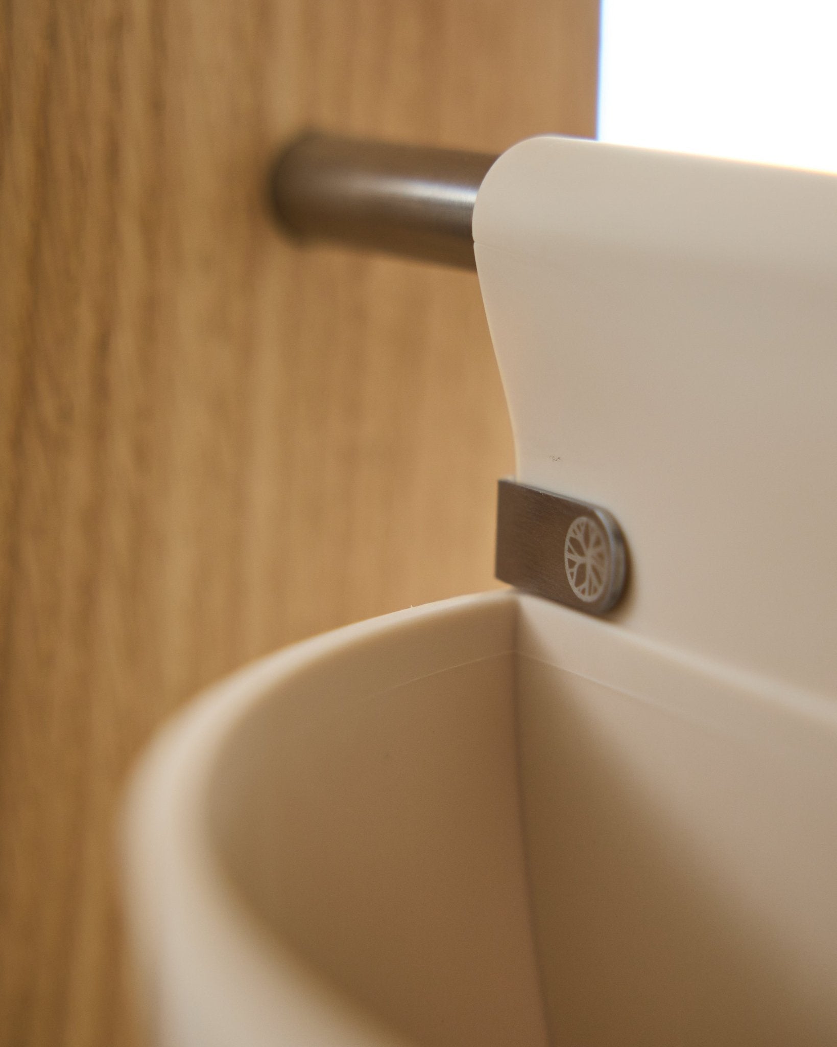 Primo piano di Gro | Soft Pocket / BM2 (4 l) in beige chiaro di WoodUpp, appeso a una barra in metallo montata sul legno; sfondo sfocato. Accessorio acustico nordico.