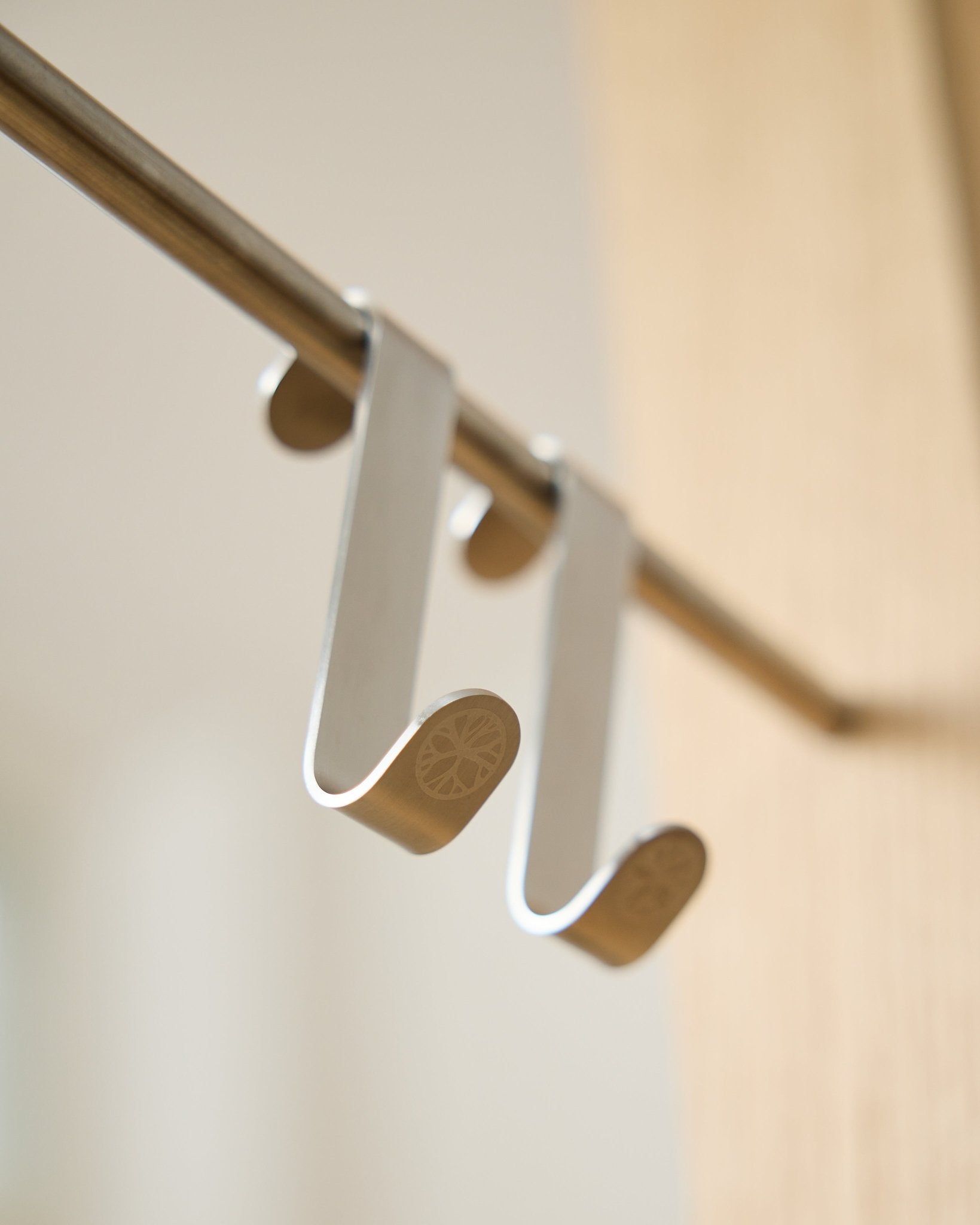 Alva S-Hook BM1  BM2 di WoodUpp, due ganci in steel inox con estremità piatte incise, pensati per appendere accessori a barre Akupanel horizontal.