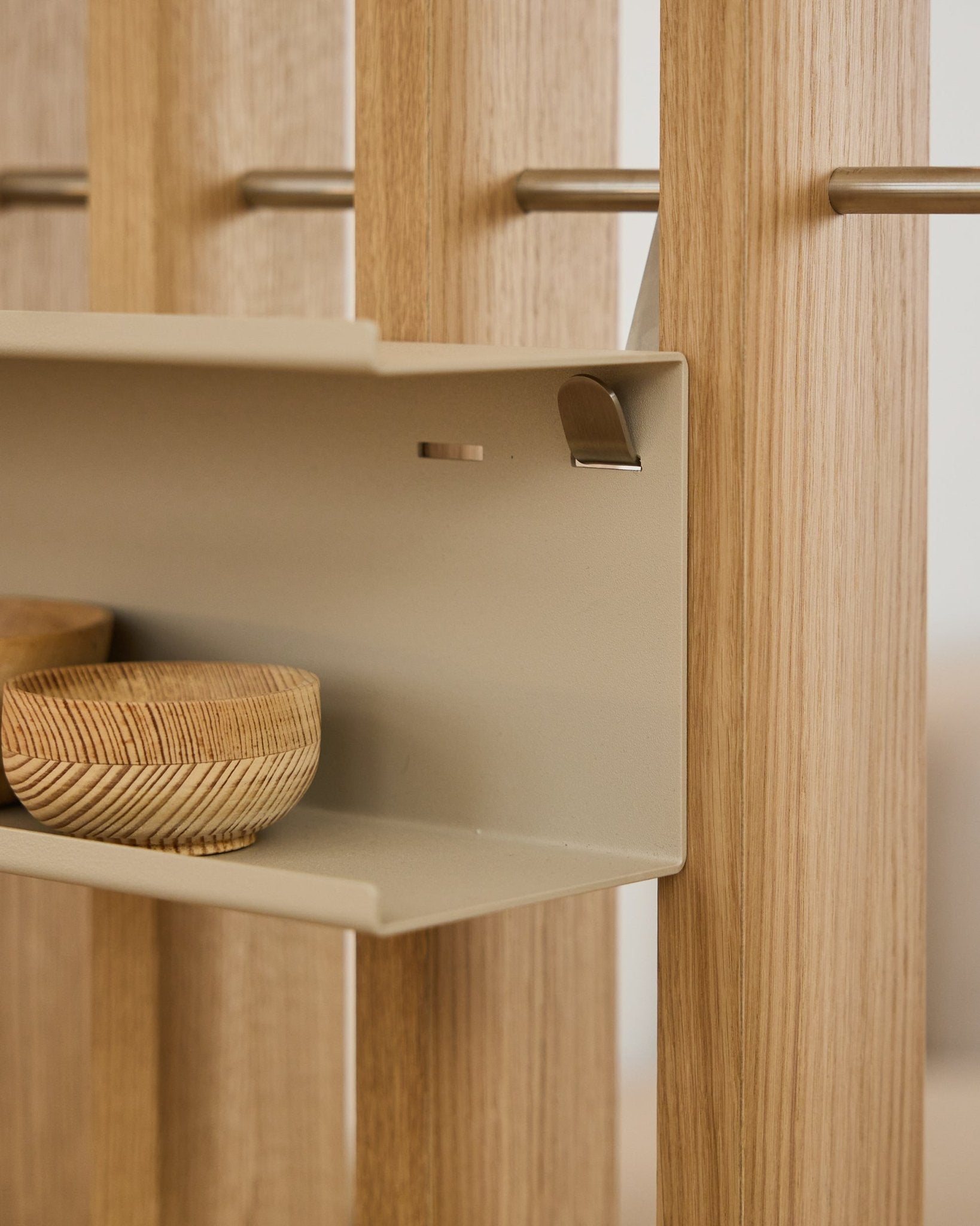 Primo piano di WoodUpp Nell Double Metal Shelf / BM1 in beige, 63,5 cm, con ciotole intrecciate e listelli acustici in legno nordico vertical montati su aste steel.